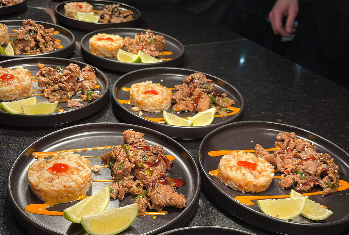 Gegrillte Gerichte stehen auf einem dunklen Tisch