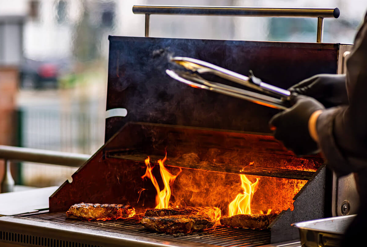 Grillmeister brät Fleisch auf einem Grill