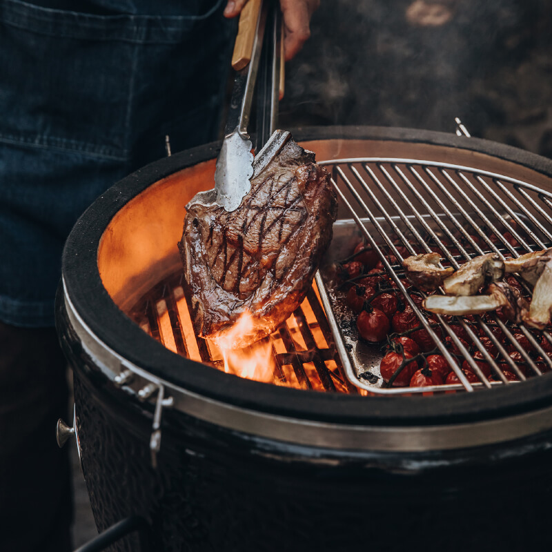 Person würzt Fleisch